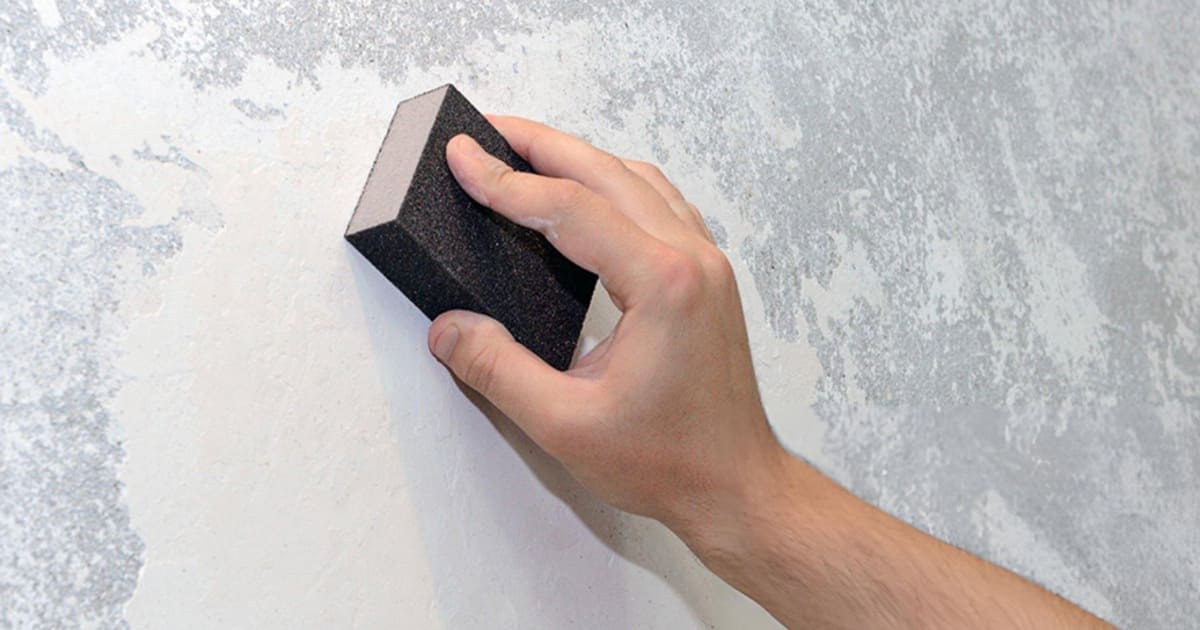 sanding drywall wall with a sand sponge