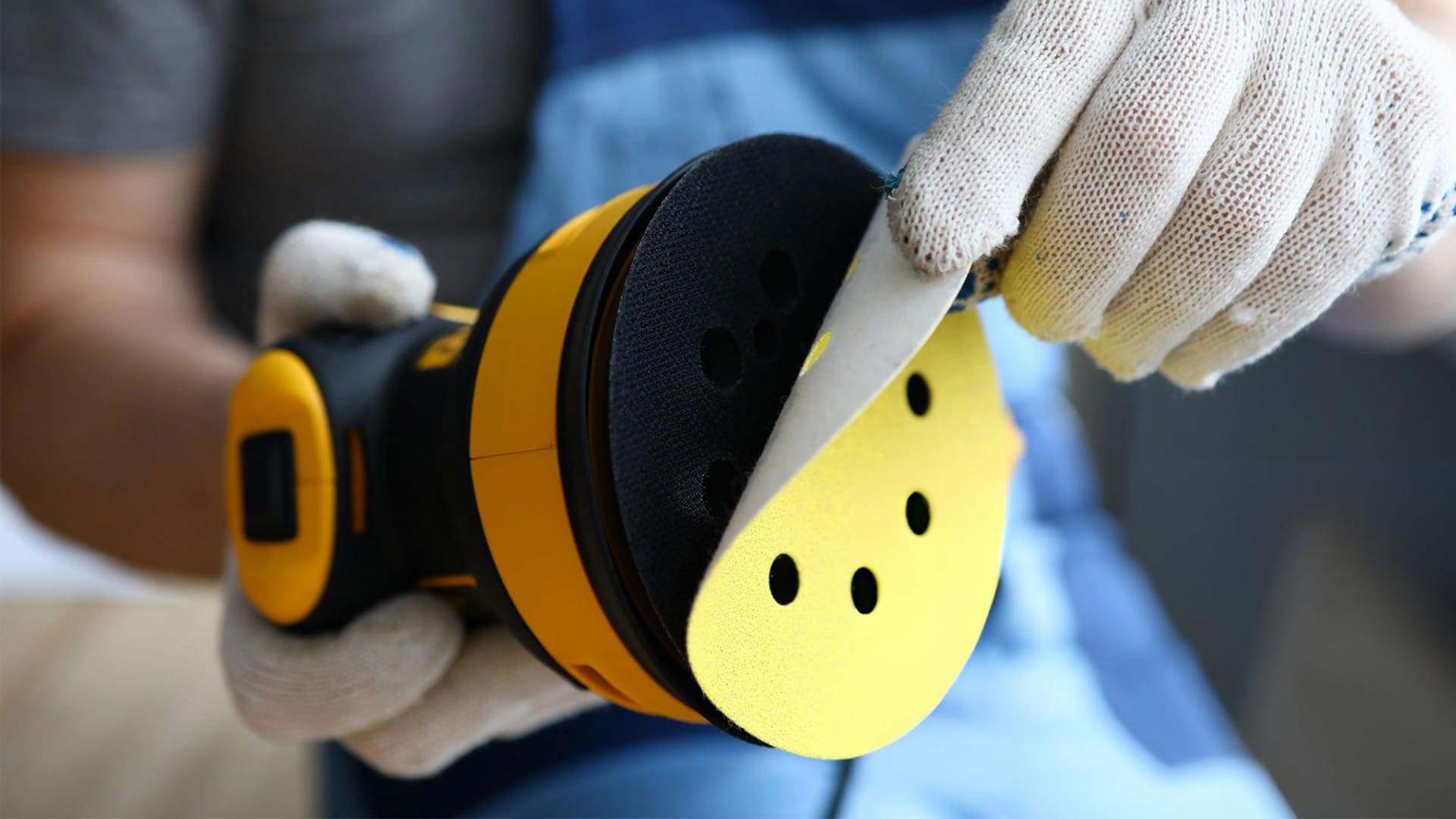  a person is removing sanding disc from the sander