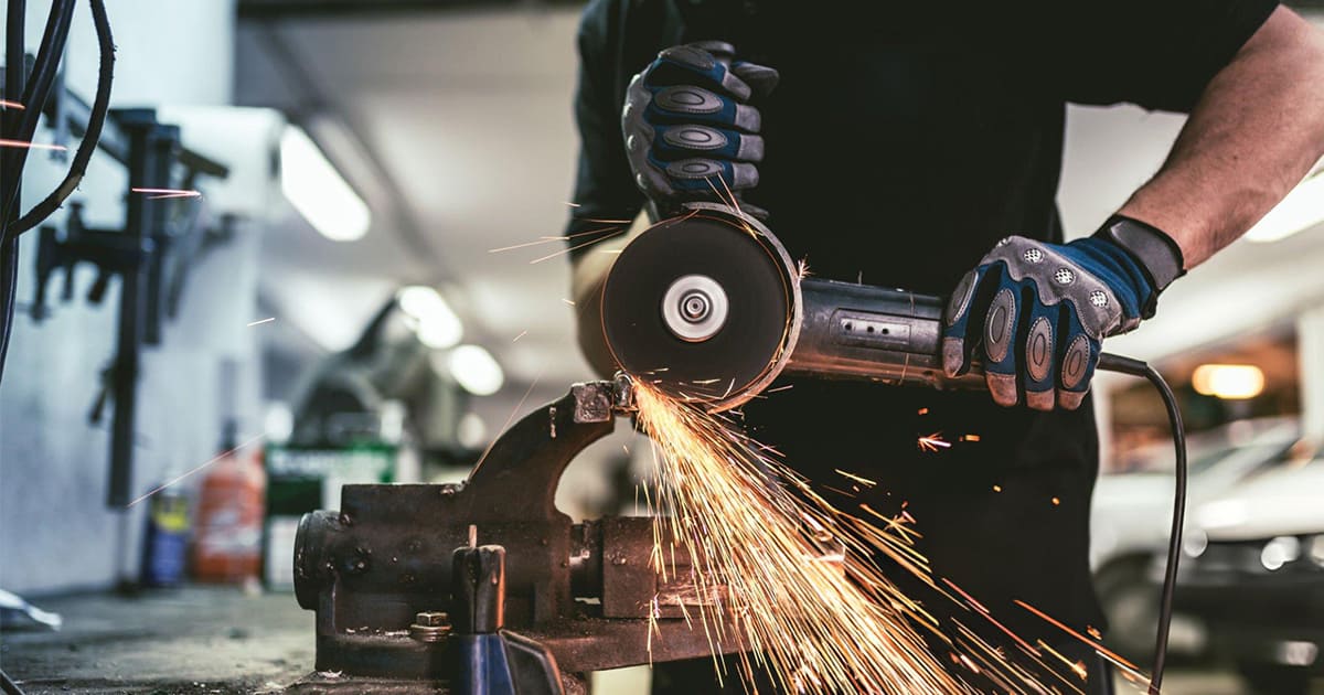 a man is using a angle grinder to cut a metal in the toolroom