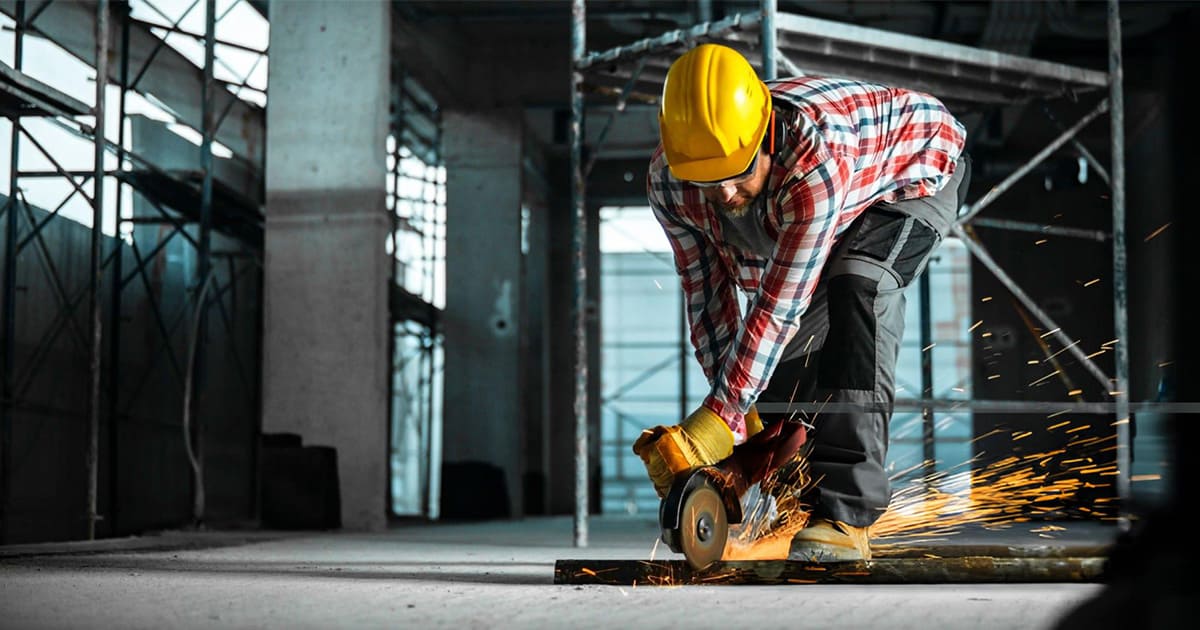 a worker is stepping on the steel pipe in order to cutting it safely.